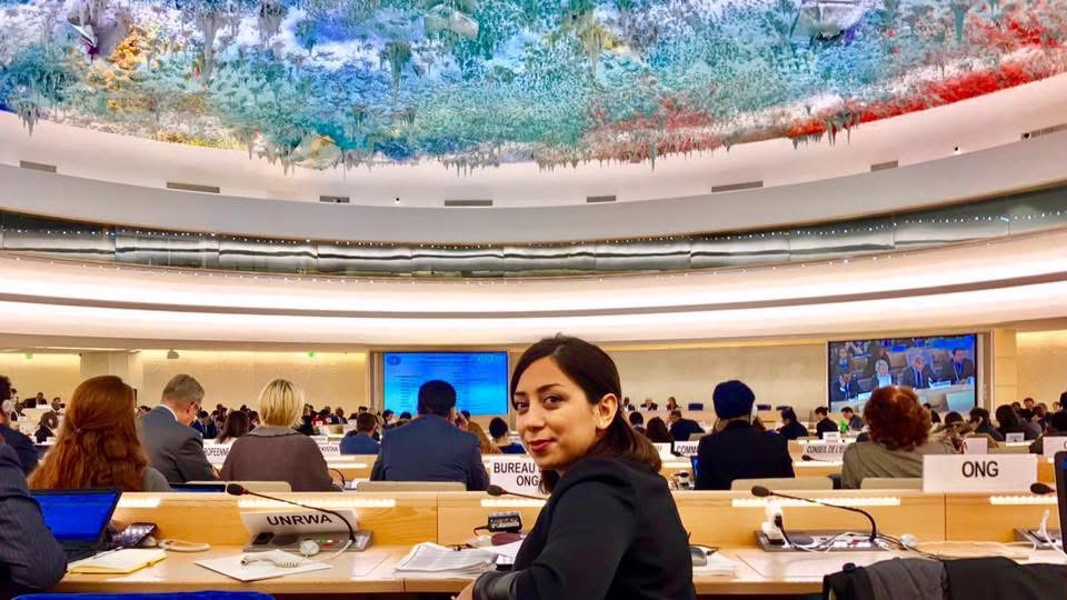Parastoo Fatemi at an NGO seat in the Human Rights Council chamber in Geneva, under its colourful domed ceiling